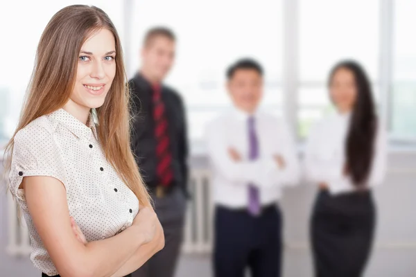 Successful business woman at foreground and business team at background — Stock Photo, Image