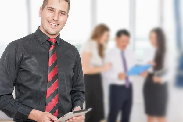 Successful young business man holding tablet pc and business team — Stock Photo, Image