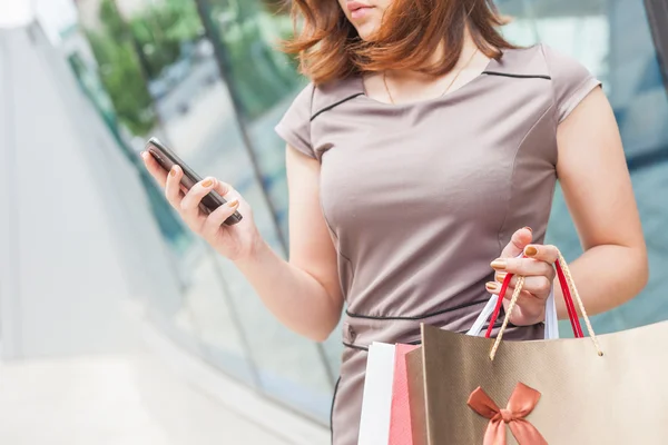 Boldog divat nő zsák használ mozgatható telefon, bevásárlóközpont — Stock Fotó