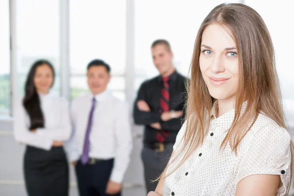 Donna d'affari di successo in primo piano e team aziendale in background — Foto Stock