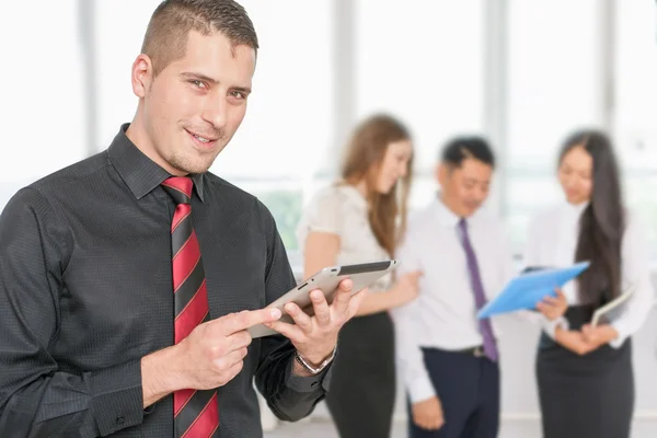 Successful young business man holding tablet pc with his team — Stock Fotó