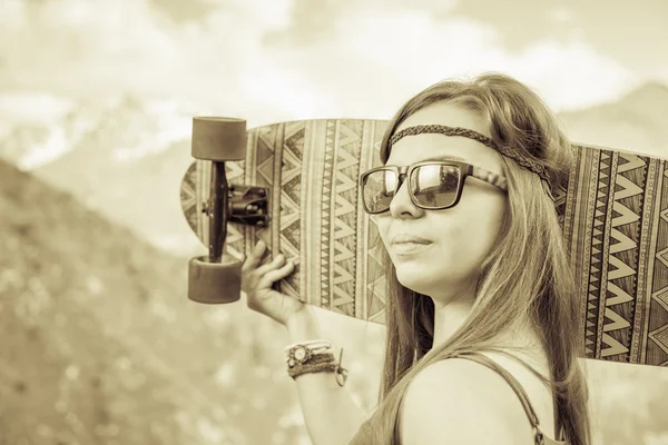 Hippie giovane e bella ragazza con longboard skateboard in montagna — Foto Stock