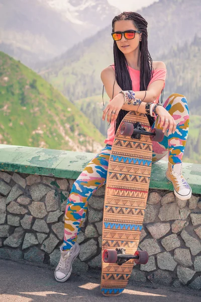 Hipster joven y hermosa chica con longboard monopatín en la montaña — Foto de Stock