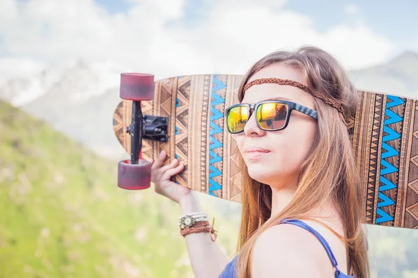 Glücklich Hipster junge und schöne Mädchen mit Skateboard am Berg — Stockfoto