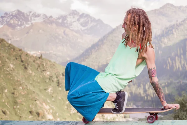 Hippie junger und gutaussehender Mann mit Longboard-Skateboard am Berg — Stockfoto