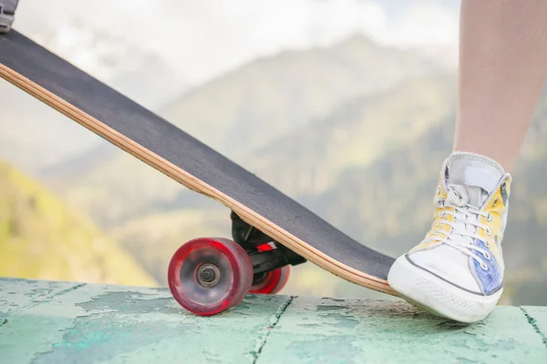 Teenager macht Trick mit Skateboard im Freien am Berg — Stockfoto