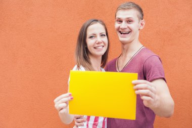 Happy people looking and holding frame at red background