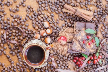 Background of chocolate bar, cup of coffee, hazelnuts, for holiday