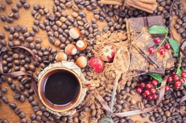 Background of chocolate bar, cup of coffee, hazelnuts, for holiday