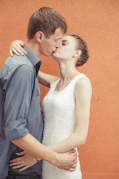 Besos pareja en rojo pared fondo — Foto de Stock