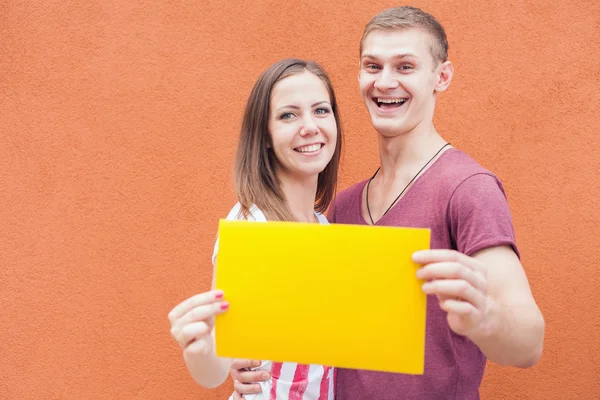 Счастливые люди смотрят и держат рамку на красном фоне — стоковое фото