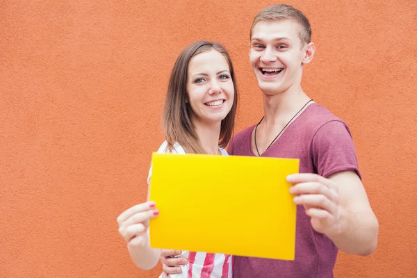 Gente feliz mirando y sosteniendo el marco en fondo rojo — Foto de Stock