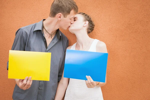 Young couple kissing and holding frames background — 图库照片