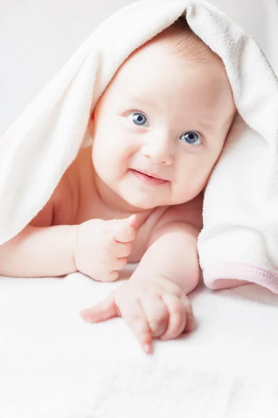 Bebê feliz após o banho, olha com toalhas brancas, sorrisos engraçados — Fotografia de Stock