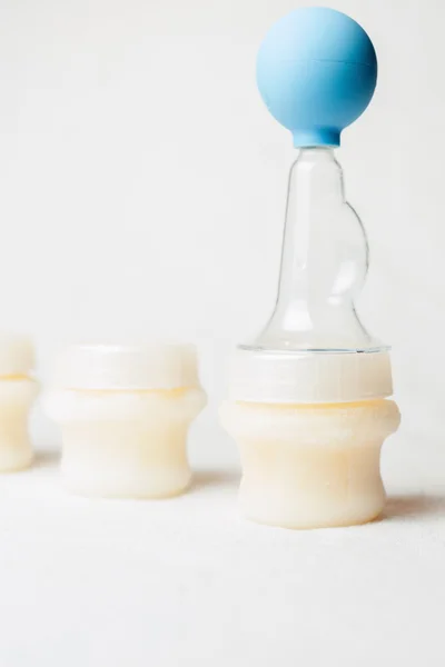 Ручной молочный насос и молоко на заднем плане — стоковое фото