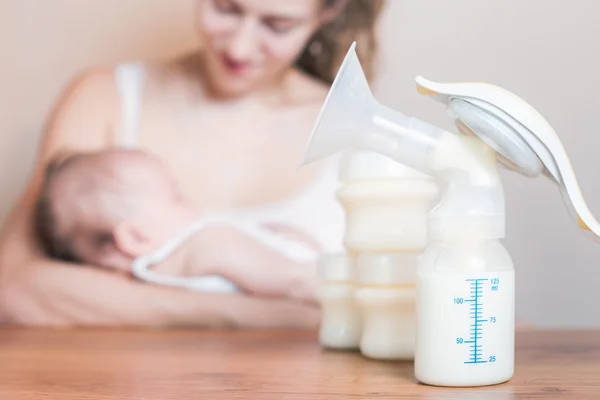 Extractor de leche manual y madre alimentando a un bebé recién nacido — Foto de Stock