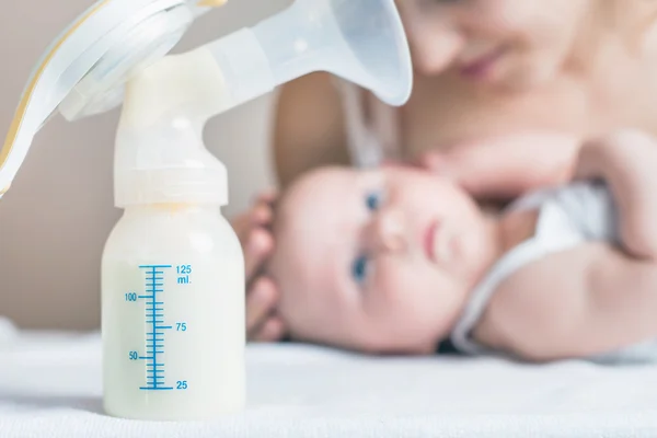 Manual breast pump and milk at background — Stock Photo, Image