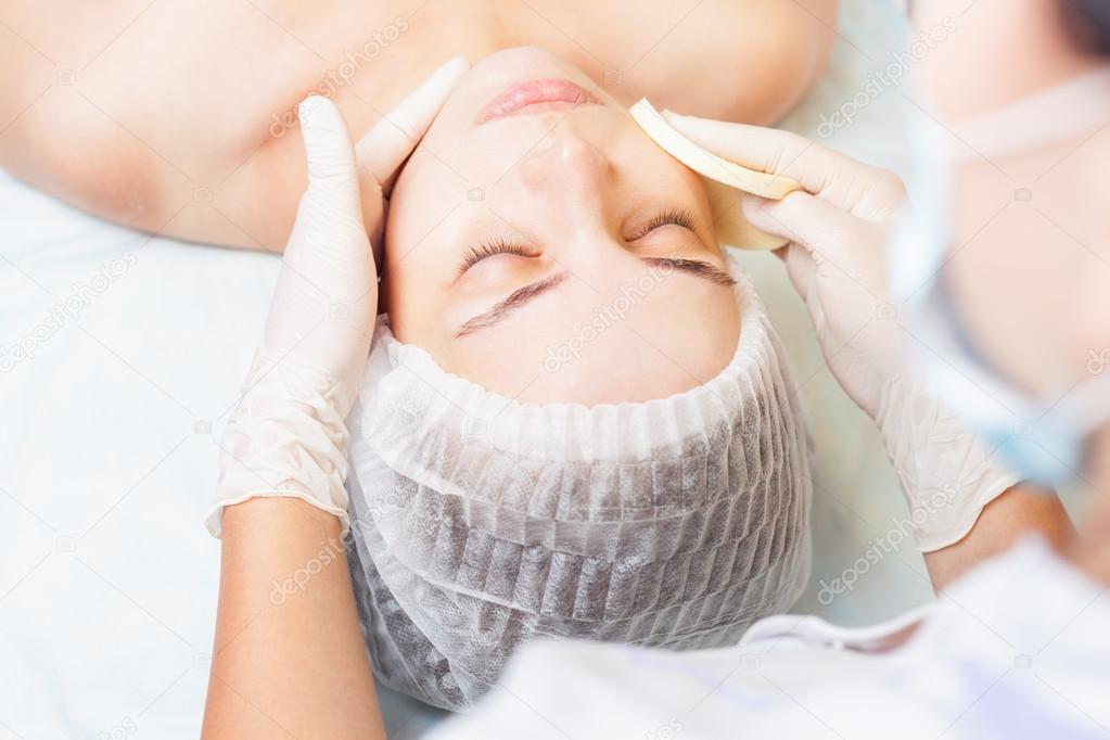 Beautiful woman in spa salon receiving face treatment, beauty concept