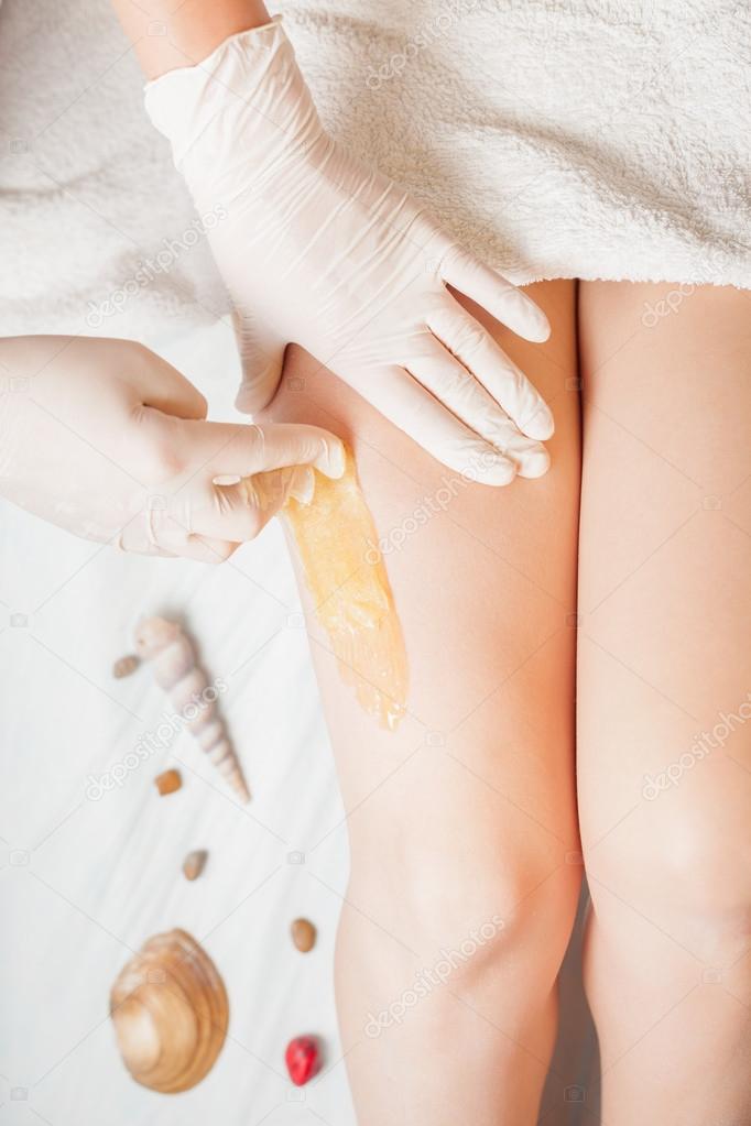 Sugaring epilation skin care with liquid sugar at legs