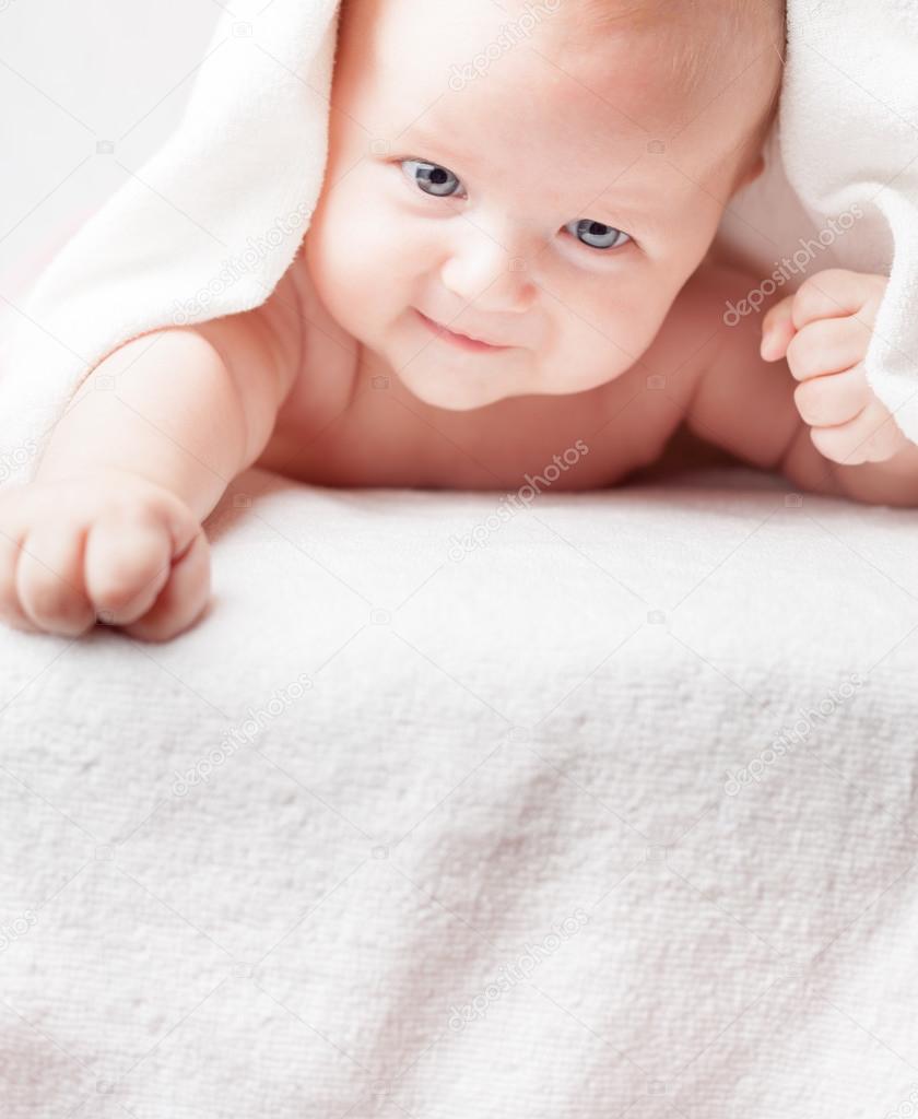 Happy baby after bathing, looks down on copy space