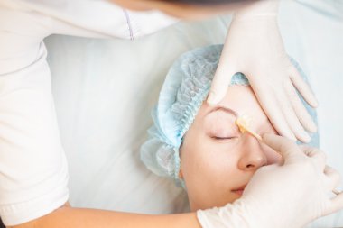 Epilasyon veya düzeltme kaş alma spa salonda güzel kadın