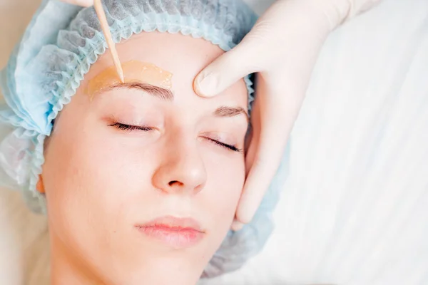 Beautiful woman in spa salon receiving epilation or correction eyebrow — Stock Photo, Image