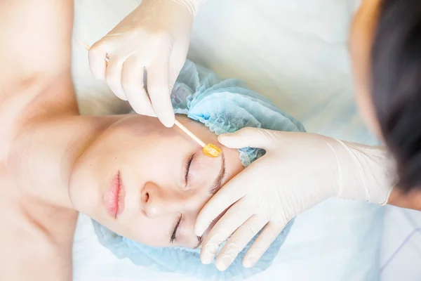 Hermosa mujer en el salón de spa recibiendo depilación o corrección de cejas —  Fotos de Stock