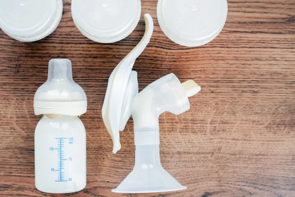ミルクと手動胸ポンプと赤ちゃんのボトルの背景 — ストック写真