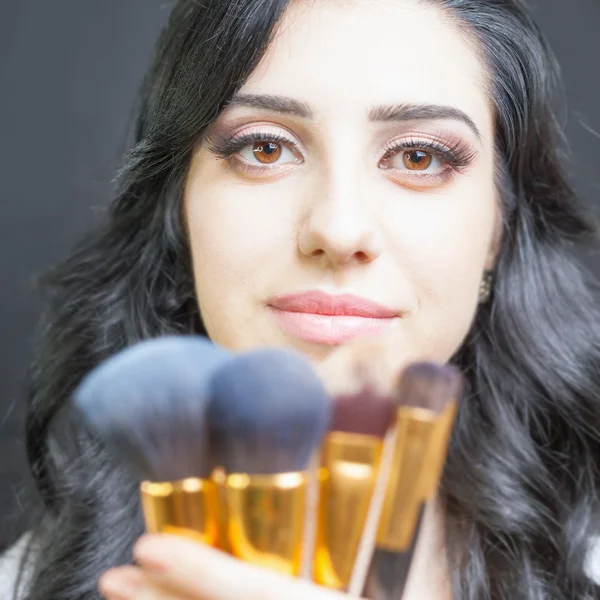 Belle femme au salon de beauté avec ensemble de pinceaux de maquillage — Photo