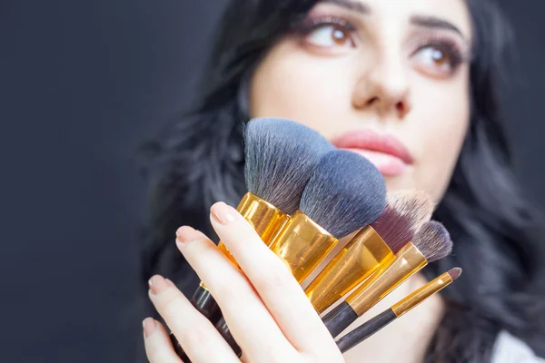 Belle femme au salon de beauté avec ensemble de pinceaux de maquillage — Photo