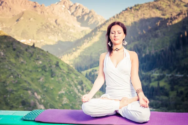 Hermosa mujer relajándose y meditando al aire libre en la montaña —  Fotos de Stock