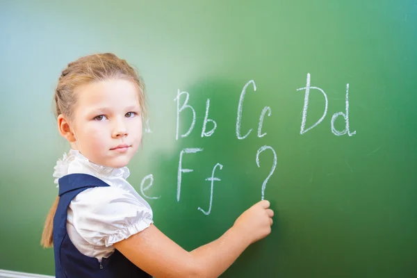 Schoolgirl wrote in chalk on blackboard and teach English language — Stock Photo, Image