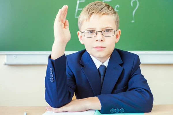 Schoolboy ready to answer and raised hand up — Zdjęcie stockowe