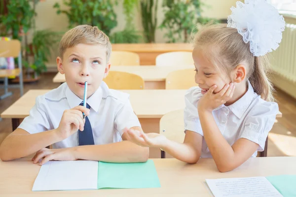 Students or classmates in school classroom sitting together at desk — Stock Photo, Image