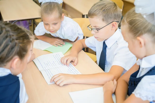 Group of schoolchildren at school classroom sitting at desk — Φωτογραφία Αρχείου