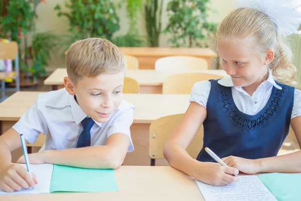 Studenti nebo spolužáci ve škole ve třídě seděli spolu u stolu — Stock fotografie