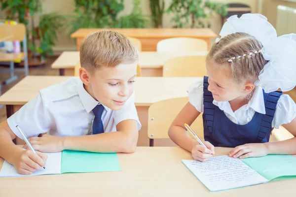Students or classmates in school classroom sitting together at desk — Stock Photo, Image