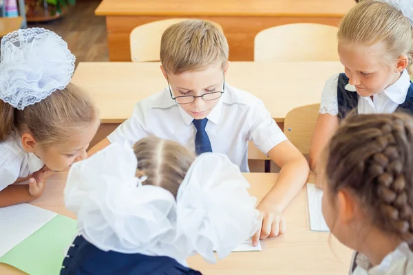 Group of schoolchildren at school classroom sitting at desk — Stok fotoğraf