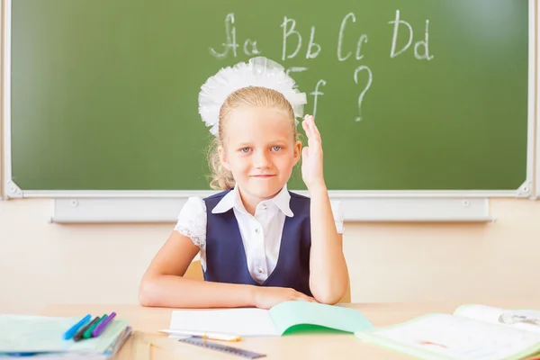 Gadis sekolah duduk di meja, kelas sekolah, di latar belakang papan — Stok Foto