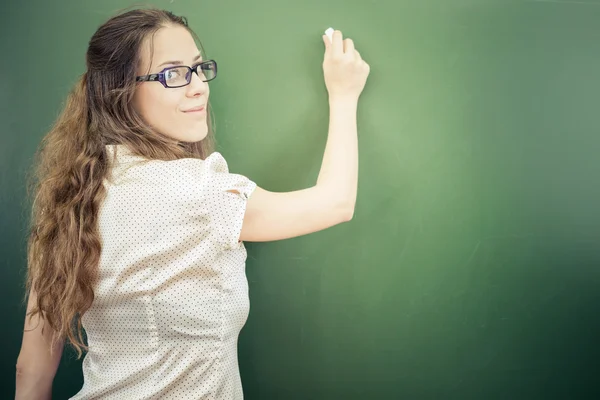 Teacher or student wrote on blackboard with chalk at classroom — Zdjęcie stockowe