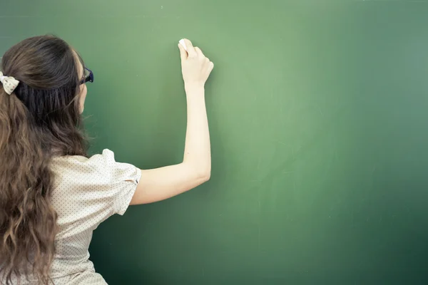 Teacher or student wrote on blackboard with chalk at classroom — Stock Fotó