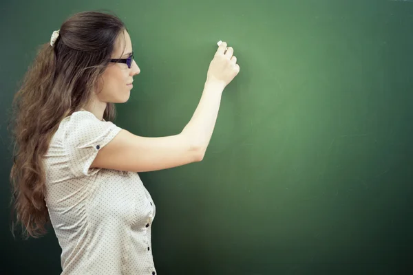 Teacher or student wrote on blackboard with chalk at classroom — Zdjęcie stockowe