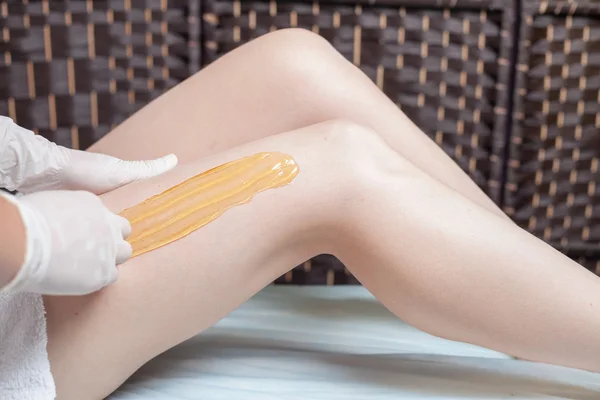 Sugaring epilation cuidados com a pele com açúcar líquido nas pernas — Fotografia de Stock