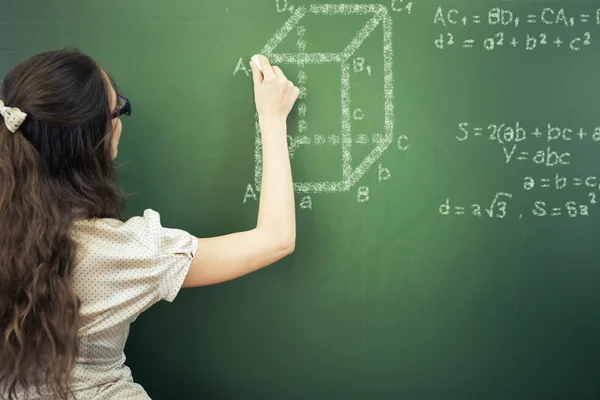 Smart student or teacher drawing mathematic formula at blackboard — Stock Photo, Image