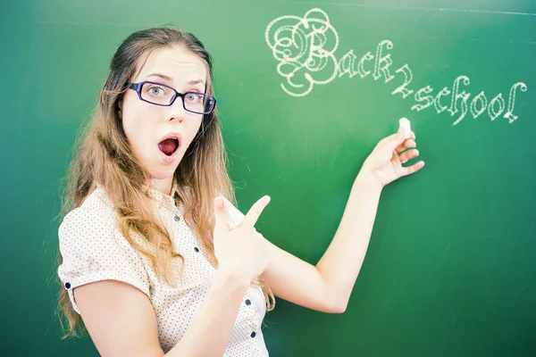 Jovem professor feliz ou estudante apontando para a escola — Fotografia de Stock