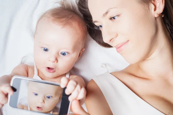 Funny baby girl with mom make selfie on mobile phone — Stock Photo, Image