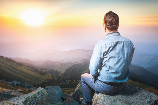 Businessman at the top of the mountain sitting and thinking — Stock Photo, Image