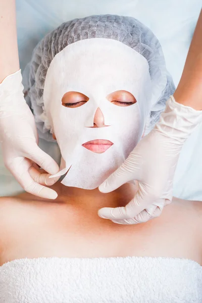 Kadın rahatlatıcı spa salonda beyaz yüz maskesi uygulama — Stok fotoğraf