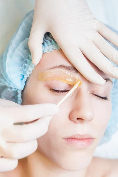 Beautiful woman in spa salon receiving epilation or correction eyebrow — Stock Photo, Image