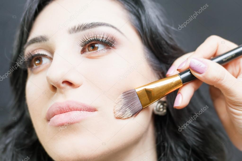 Beautiful woman at beauty salon receives makeup